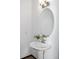 Well-lit powder room with a pedestal sink, decorative mirror, and modern fixtures at 9811 Crystallo Ct, Parker, CO 80134