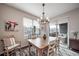 Bright dining area with a wooden table, stylish chandelier, and access to the outdoor patio at 11450 Booth Falls Ct, Parker, CO 80134