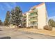 Exterior view of condo building featuring balconies, mature trees and surrounding landscaping at 7801 W 35Th Ave # 409, Wheat Ridge, CO 80033