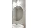 A well-lit bathroom features a new vanity with a large, oval mirror at 1854 Westport Ave, Berthoud, CO 80513