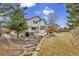 Landscaped backyard featuring a stone path, mature trees, and outdoor seating area at 5885 Kingsfield St, Castle Rock, CO 80104