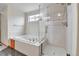 Primary bathroom features a soaking tub, glass enclosed shower and window at 5885 Kingsfield St, Castle Rock, CO 80104