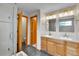 Bathroom with double sink vanity, wood cabinets, tile floors, and glass enclosed shower at 5885 Kingsfield St, Castle Rock, CO 80104