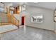 Spacious foyer with tile flooring, a staircase with wood railings, and a bright red front door at 5885 Kingsfield St, Castle Rock, CO 80104