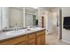 Bathroom with double sink vanity and large mirror, offering plenty of space and storage at 12728 Jasmine St # E, Thornton, CO 80602