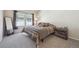 Bedroom with neutral decor, including carpet, and a large window that provides natural light at 12728 Jasmine St # E, Thornton, CO 80602
