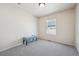 Cozy bedroom featuring a window, neutral walls, and a bench at 12728 Jasmine St # E, Thornton, CO 80602
