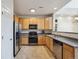 Functional kitchen featuring light wooden cabinets, stainless steel appliances, and tile flooring at 12728 Jasmine St # E, Thornton, CO 80602