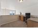 Home office space with built-in desk, neutral carpet, and natural light from the nearby window at 12728 Jasmine St # E, Thornton, CO 80602