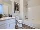 Bathroom features a shower over tub with white tile surround and stylish wood-look flooring at 17014 Carr Ave, Parker, CO 80134
