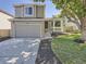 Charming two-story home featuring a well-maintained lawn, gray siding, and an attached two-car garage at 17014 Carr Ave, Parker, CO 80134