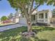 View of a well-maintained two-story home with a manicured front lawn and attached garage with a large tree at 17014 Carr Ave, Parker, CO 80134