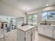 Kitchen featuring white cabinets, a breakfast bar, and an open view to the living room and backyard at 17014 Carr Ave, Parker, CO 80134