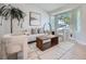 Bright living room features neutral furniture, stylish decor, hardwood floors, and natural light through large bay window at 17014 Carr Ave, Parker, CO 80134