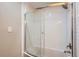 Clean bathroom featuring a bathtub with a sliding glass door and white subway tile surround at 7455 E Quincy Ave # 103, Denver, CO 80237