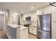 Well-lit kitchen featuring a breakfast bar, stainless steel refrigerator, and ample storage space at 7455 E Quincy Ave # 103, Denver, CO 80237