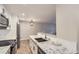 Bright kitchen boasts modern white cabinets, granite countertops, and stainless steel appliances at 7455 E Quincy Ave # 103, Denver, CO 80237