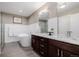 Elegant bathroom featuring a soaking tub, marble countertop, wood cabinets and tile flooring at 2004 S Galapago St, Denver, CO 80223