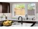 Close up of a kitchen sink with double faucet, granite countertop, and stainless steel appliances at 2004 S Galapago St, Denver, CO 80223