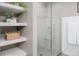 Beautiful bathroom with glass shower, tiled walls, and floating shelves with decorative items at 2004 S Galapago St, Denver, CO 80223