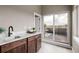 Wet bar featuring dark cabinets, a marble countertop, sink, and access to a balcony at 2004 S Galapago St, Denver, CO 80223