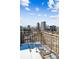 City skyline view from a balcony with iron seating and snow covered flooring at 1223 Race St # 101, Denver, CO 80206