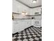 Updated kitchen with white cabinets, stainless steel appliances, and black and white tiled floors at 1223 Race St # 101, Denver, CO 80206