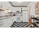 Bright kitchen featuring white cabinets, stainless steel appliances, and a black and white checkerboard floor at 1223 Race St # 101, Denver, CO 80206