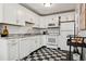 Kitchen with white cabinets, black and white checkered floors, and stainless steel appliances at 1223 Race St # 101, Denver, CO 80206