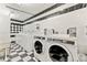 Shared laundry room with modern washer and dryer units, plus a tiled floor at 1223 Race St # 101, Denver, CO 80206