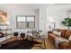 Living room with brown leather sofa, area rug, side table, and large picture window at 1223 Race St # 101, Denver, CO 80206