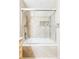 Bathroom featuring a bathtub with tile walls, shower head, and a glass door at 11647 E Wesley Ave, Aurora, CO 80014