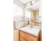 Bathroom vanity with a bright mirror, modern faucet, and a window at 11647 E Wesley Ave, Aurora, CO 80014
