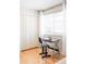 Bedroom featuring hardwood floors, white closet doors, and a large window at 11647 E Wesley Ave, Aurora, CO 80014