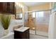 Tiled bathroom with tub, shower, and dark-wood sink cabinet at 3559 Hudson St, Denver, CO 80207