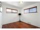 Empty room with hardwood floors and natural light from two windows at 3559 Hudson St, Denver, CO 80207