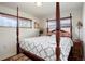 Well-lit bedroom with wood-trimmed windows and dark, four-poster bed at 3559 Hudson St, Denver, CO 80207