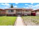 Charming single-story home with brick accents, covered porch and walkway with beautiful landscaping at 3559 Hudson St, Denver, CO 80207