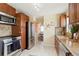 Bright kitchen featuring stainless steel appliances, granite countertops, wood cabinetry, and tile floors at 3559 Hudson St, Denver, CO 80207