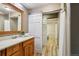 Bathroom features a wood vanity and a sliding door leading to toilet and shower areas at 20033 Silver Ranch Rd, Conifer, CO 80433