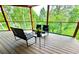 Covered deck with a metal railing and outdoor seating with forest views at 20033 Silver Ranch Rd, Conifer, CO 80433