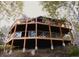 Rustic home featuring a large, multi-level wooden deck with glass and cable railings, perched on a hillside among mature trees at 20033 Silver Ranch Rd, Conifer, CO 80433