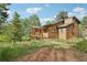 Exterior view of home showing landscape and charming front porch at 20033 Silver Ranch Rd, Conifer, CO 80433