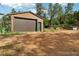 Exterior view of two-car garage building with a new looking door and a fenced area at 20033 Silver Ranch Rd, Conifer, CO 80433