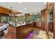 Well-appointed kitchen featuring custom wood cabinetry, an expansive island, stone flooring, and integrated appliances, perfect for cooking at 20033 Silver Ranch Rd, Conifer, CO 80433