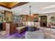 Elegant kitchen with custom wood cabinets, stone floors, and a breakfast nook with views of nature and custom lighting at 20033 Silver Ranch Rd, Conifer, CO 80433