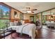 The main bedroom is spacious with dark wood floors, custom wood trim, and large windows at 20033 Silver Ranch Rd, Conifer, CO 80433