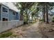 Lush landscaped backyard with mature trees, privacy fencing, and a serene walking path at 2748 S Kenton Ct, Aurora, CO 80014