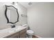Cozy half bathroom featuring a decorative mirror, pedestal sink, and neutral color palette at 2748 S Kenton Ct, Aurora, CO 80014