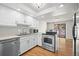 Bright kitchen featuring stainless steel appliances, white cabinets, and access to the outdoor deck at 2748 S Kenton Ct, Aurora, CO 80014